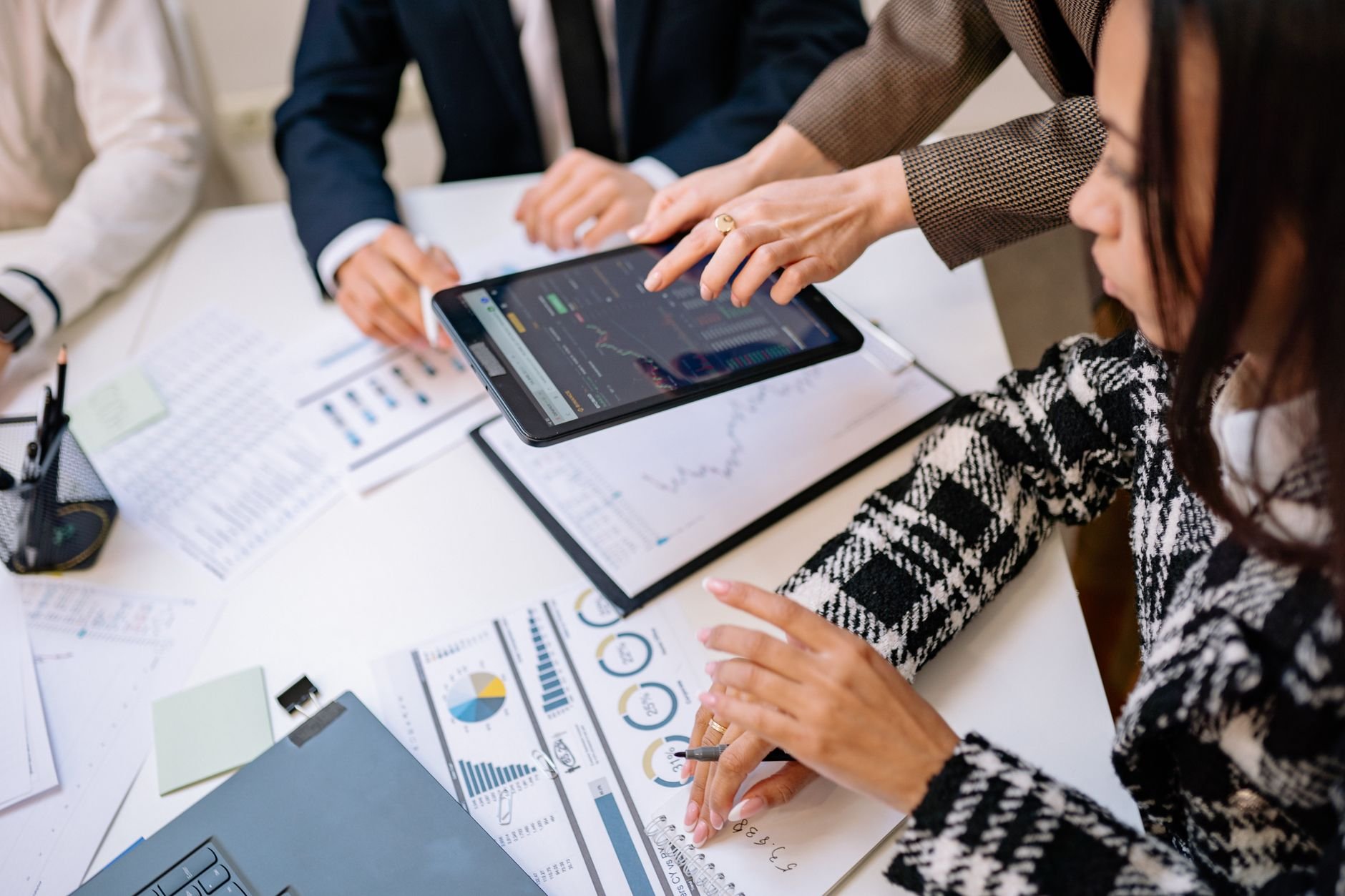Business professionals reviewing analytics on a tablet, representing Autyva's managed approach to AI automation